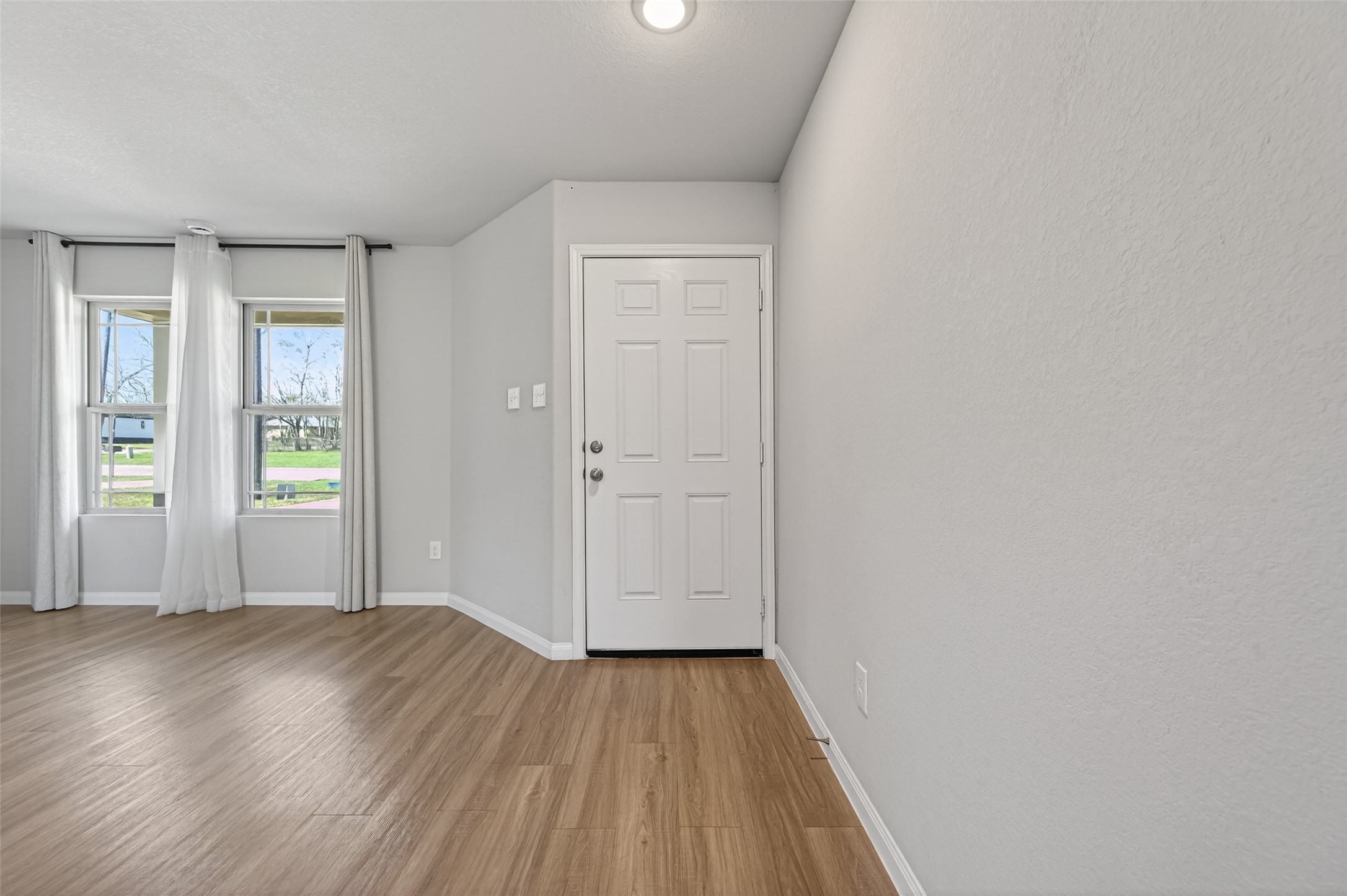 940 21st Street Hempstead, TX 77445 - Photo 4 of 32 an empty room with wooden floor and windows