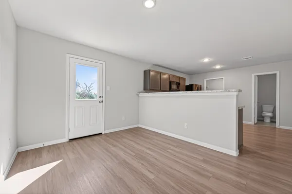a view of a kitchen with wooden floor and electronic appliances