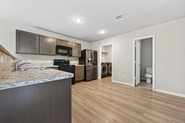 a kitchen with stainless steel appliances granite countertop a sink stove and refrigerator