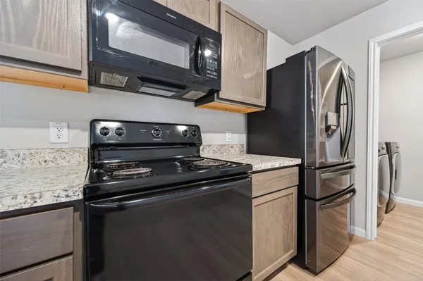 a kitchen with stainless steel appliances granite countertop a refrigerator stove and microwave