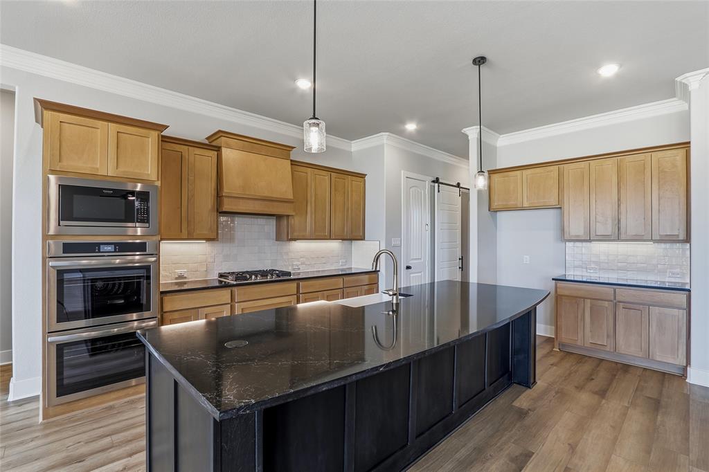 812 Vly Rdg Road Van Alstyne, TX 75495 - Photo 7 of 33 a kitchen with stainless steel appliances granite countertop a sink a stove and a wooden floors