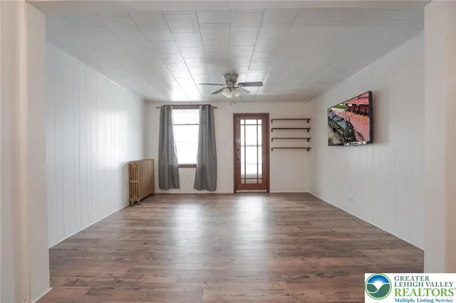 a view of an empty room with wooden floor