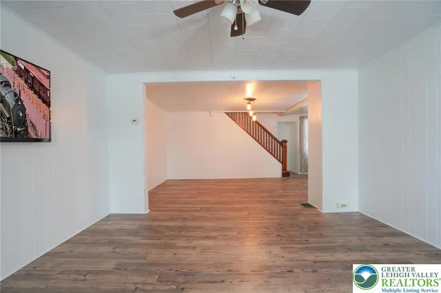 a kitchen with stainless steel appliances a dining table chairs stove refrigerator and cabinets