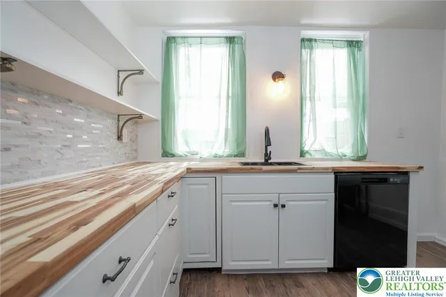 a kitchen with a stove a sink and a window