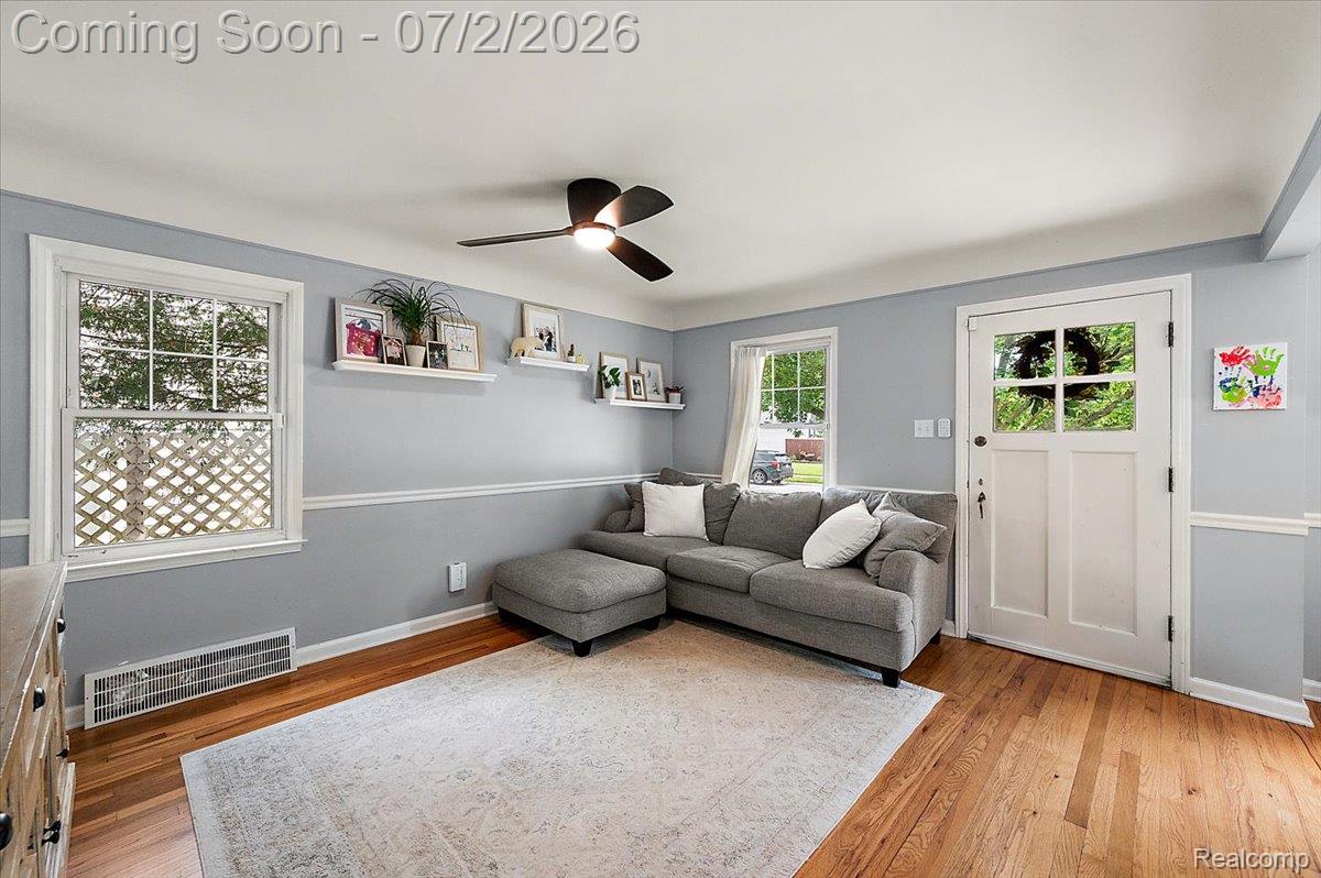 1706 Princeton Road Berkley, MI 48072 - Photo 7 of 49 Bright room featuring wood-finish flooring, light blue walls with white chair rail molding, and multiple windows