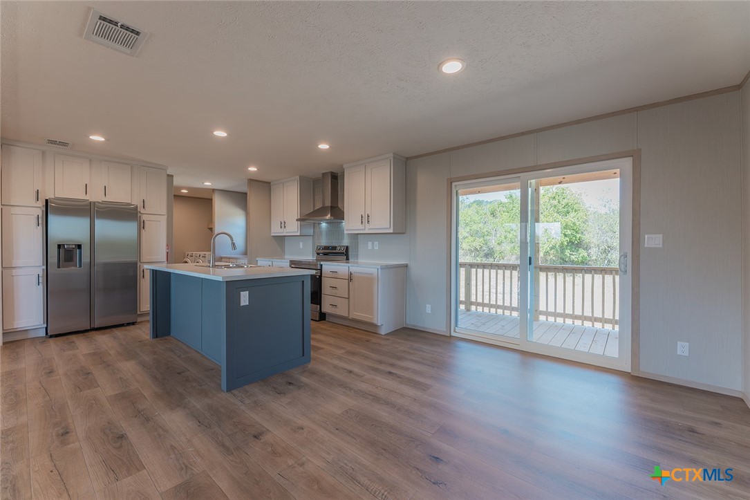 3505 Ivy Gap Road Kempner, TX 76539 - Photo 13 of 43 a large kitchen with stainless steel appliances granite countertop a large counter top a wooden floors and a large window
