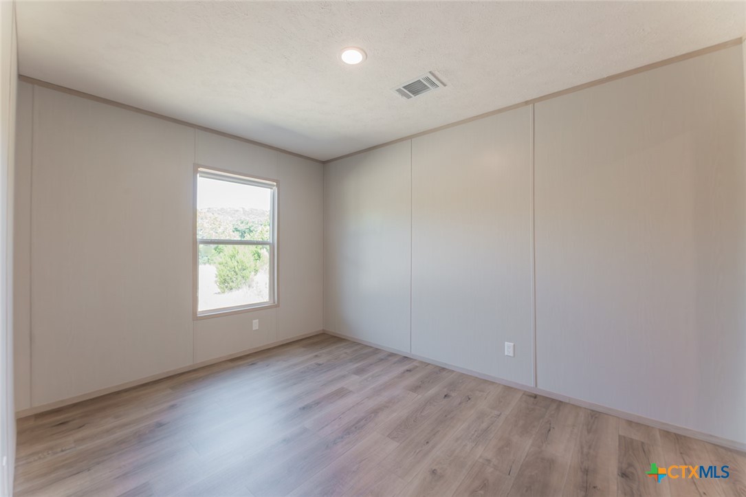 3505 Ivy Gap Road Kempner, TX 76539 - Photo 30 of 43 an empty room with wooden floor and windows