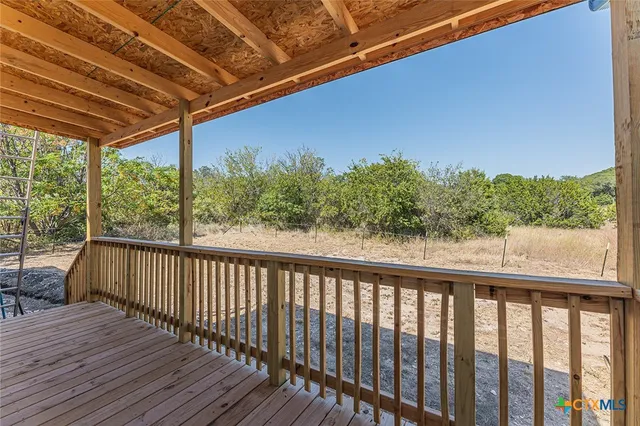 a view of balcony with wooden floor and fence