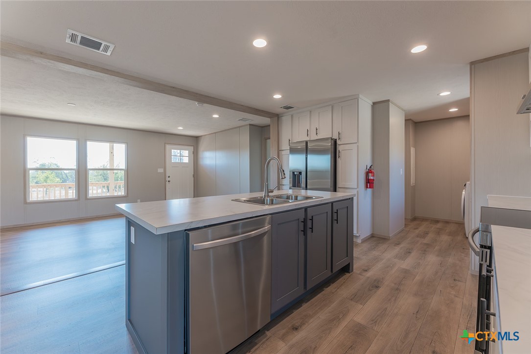 3505 Ivy Gap Road Kempner, TX 76539 - Photo 8 of 43 a kitchen with kitchen island granite countertop a sink and wooden cabinets