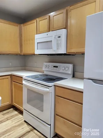 a kitchen with granite countertop cabinets stainless steel appliances and a counter space