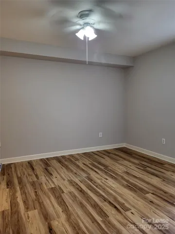 a view of an empty room with a chandelier fan