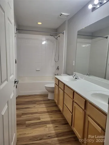 a bathroom with a double vanity sink a mirror and a bathtub