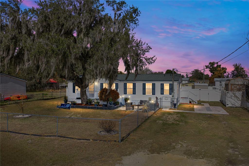 a row of palm trees in front of a house