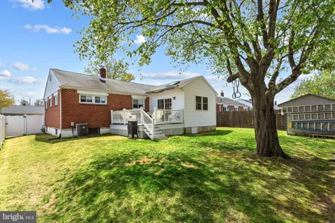 a view of a house with a big yard and large tree