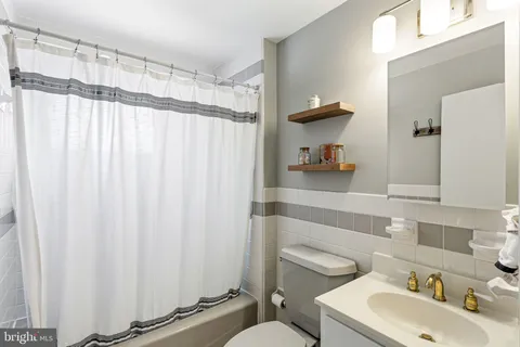 a bathroom with a sink a toilet and shower curtain