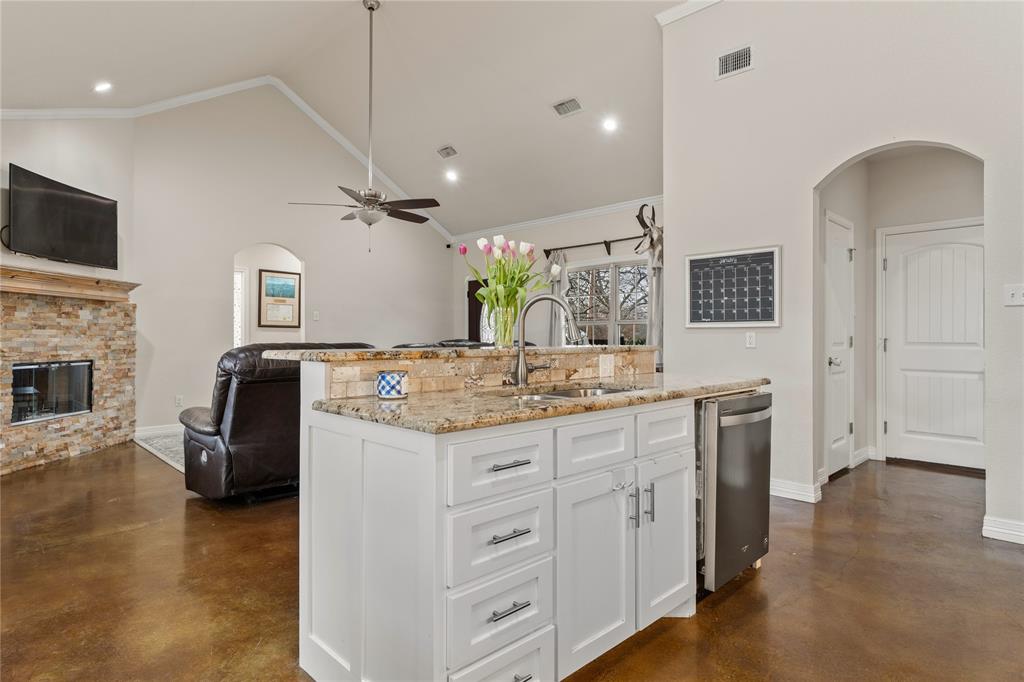 10514 Mesa Drive Waco, TX 76708 - Photo 35 of 37 Kitchen with arched walkways, open floor plan, concrete floors, light stone countertops, and high vaulted ceiling