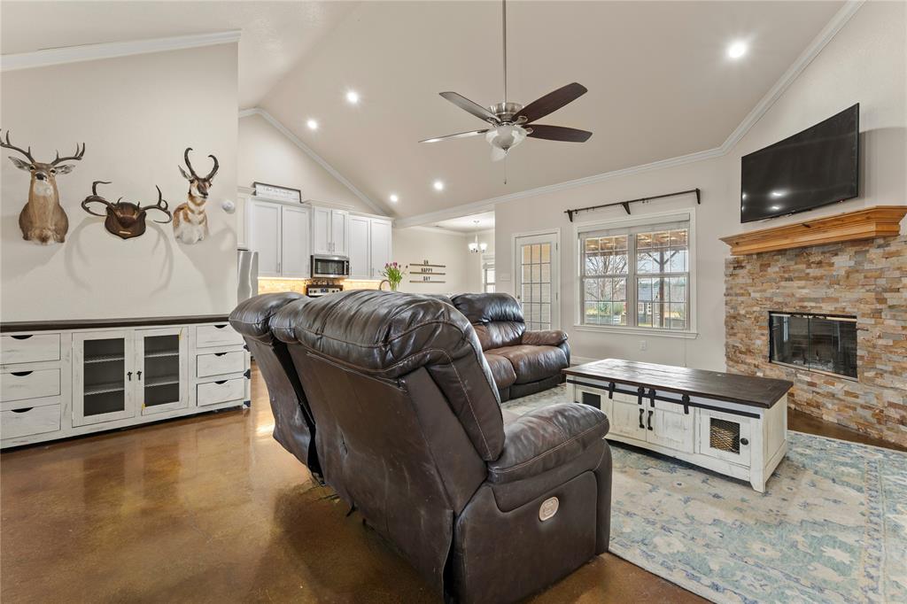 10514 Mesa Drive Waco, TX 76708 - Photo 2 of 39 Living area with concrete flooring, a stone fireplace, crown molding, recessed lighting, and ceiling fan