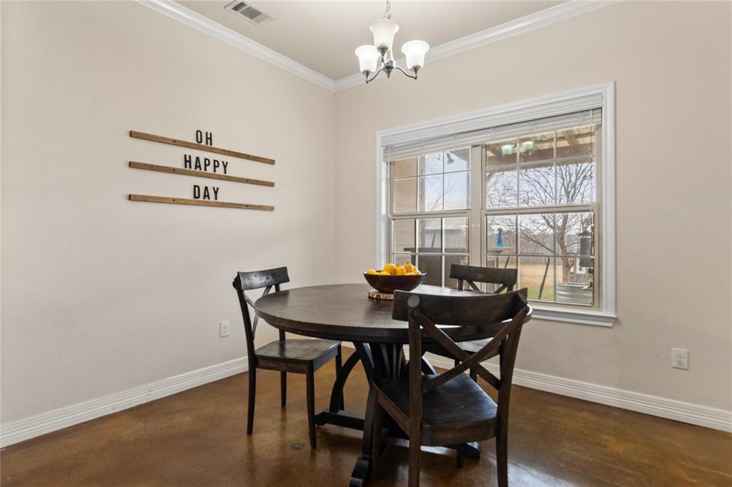 10514 Mesa Drive Waco, TX 76708 - Photo 20 of 37 Dining space featuring ornamental molding, finished concrete floors, and a chandelier