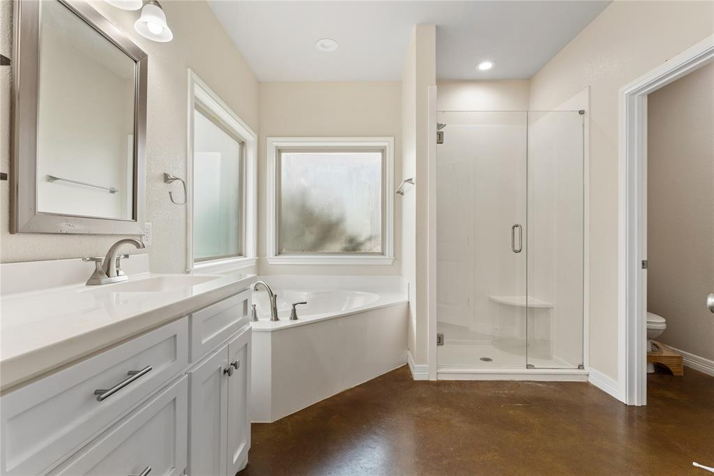10514 Mesa Drive Waco, TX 76708 - Photo 7 of 37 Bathroom with finished concrete floors, a stall shower, a bath, and vanity