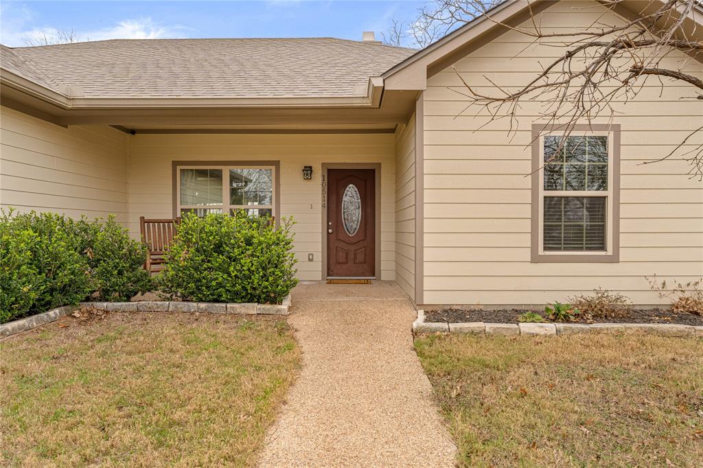 10514 Mesa Drive Waco, TX 76708 - Photo 9 of 37 Doorway to property with covered porch, a yard, and roof with shingles