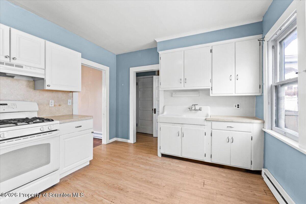 715 Alder Street Scranton, PA 18505 - Photo 11 of 38 a kitchen with granite countertop white cabinets and white appliances