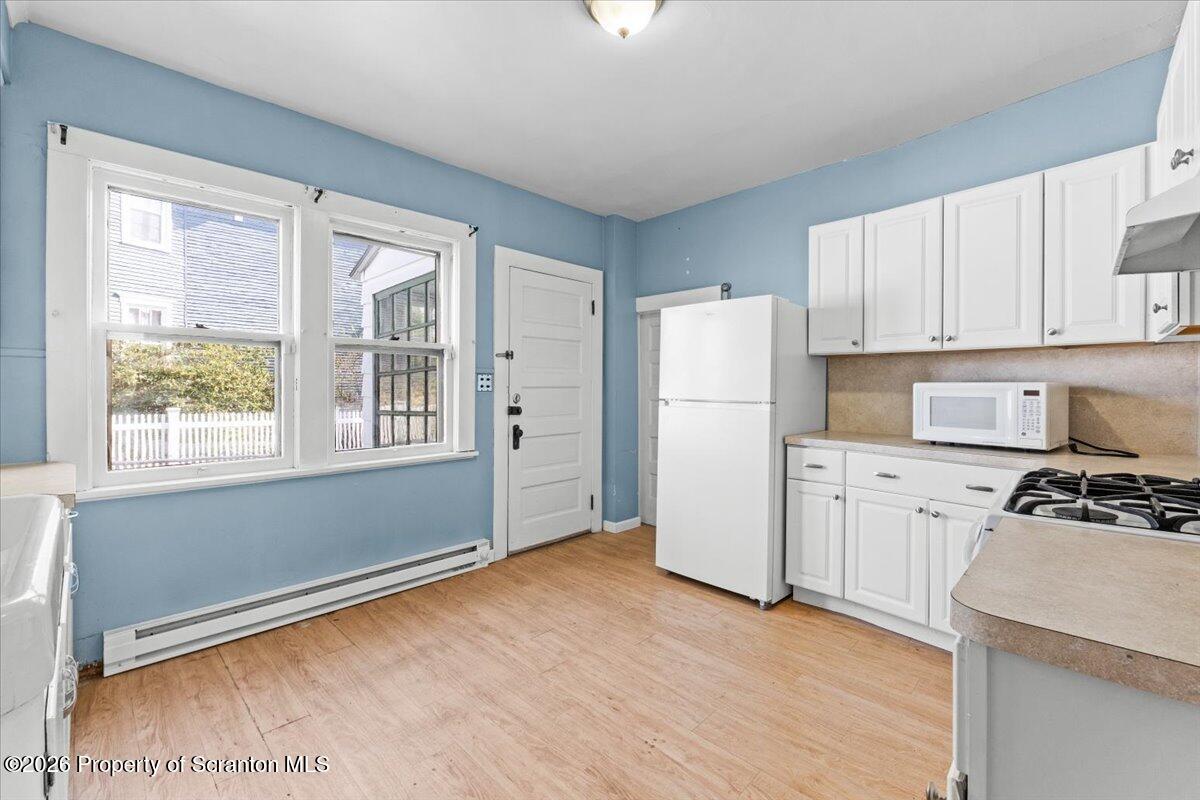 715 Alder Street Scranton, PA 18505 - Photo 12 of 38 a kitchen with a refrigerator a stove top oven and white cabinets