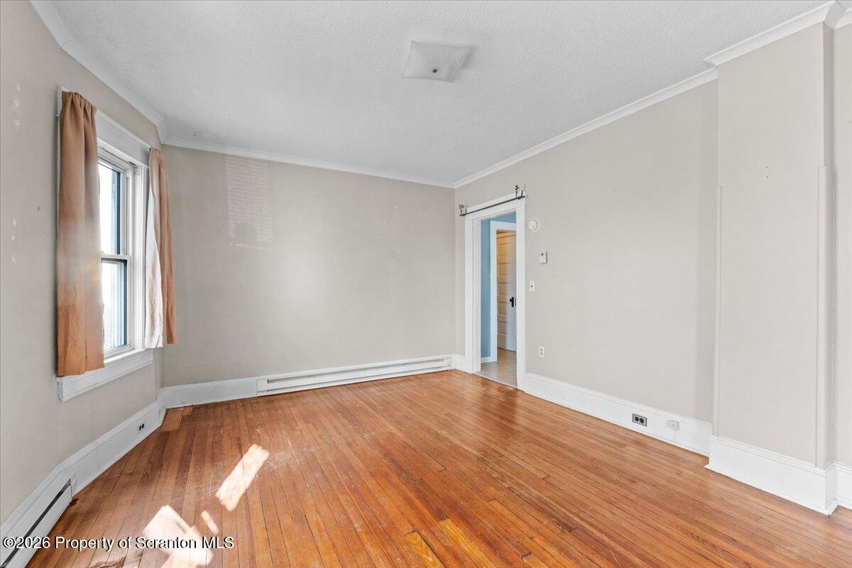 715 Alder Street Scranton, PA 18505 - Photo 14 of 38 an empty room with wooden floor and windows