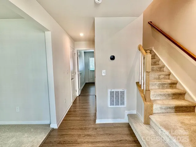 a view of a hallway with wooden floor and entryway