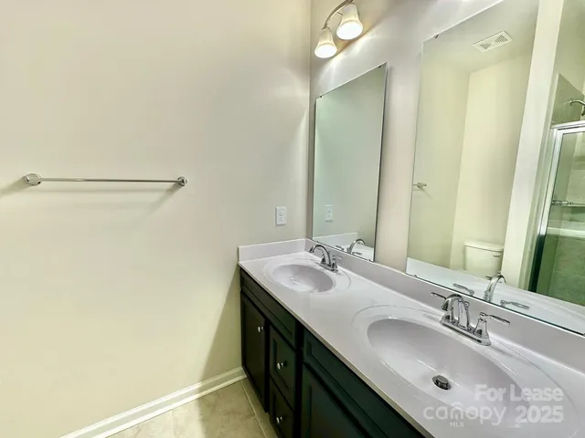 a bathroom with a double vanity sink and a mirror