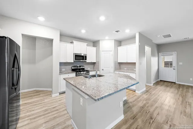 a kitchen with granite countertop a stove and a sink
