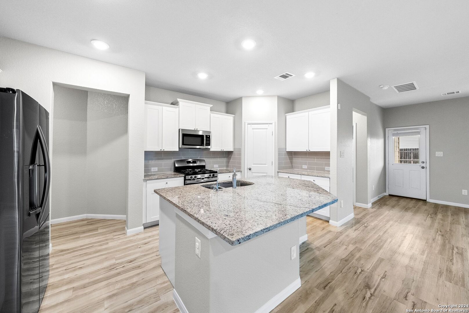 10535 Margarita Loop Converse, TX 78109 - Photo 11 of 51 a kitchen with stainless steel appliances granite countertop a refrigerator a sink dishwasher a stove and a wooden floors