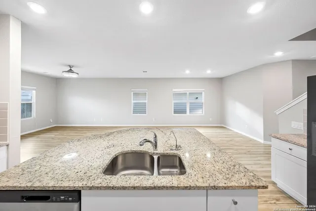 a large kitchen with kitchen island a counter top space a sink appliances and cabinets