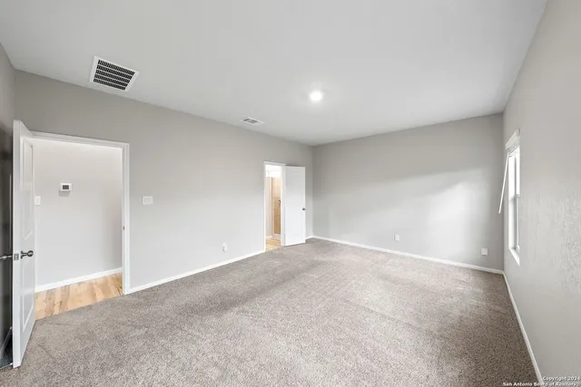 an empty room with a fireplace and windows