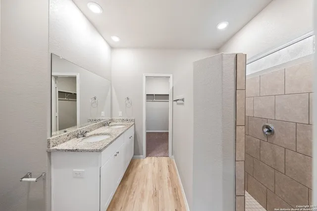 a bathroom with a granite countertop sink and a mirror