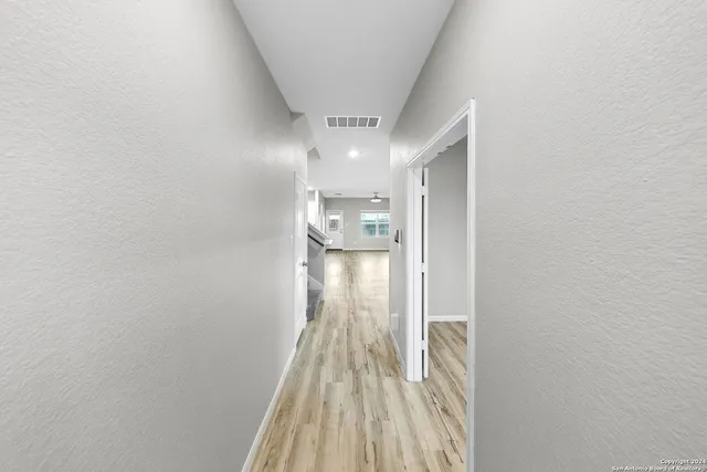 a view of a kitchen with kitchen island a sink wooden floor and stainless steel appliances