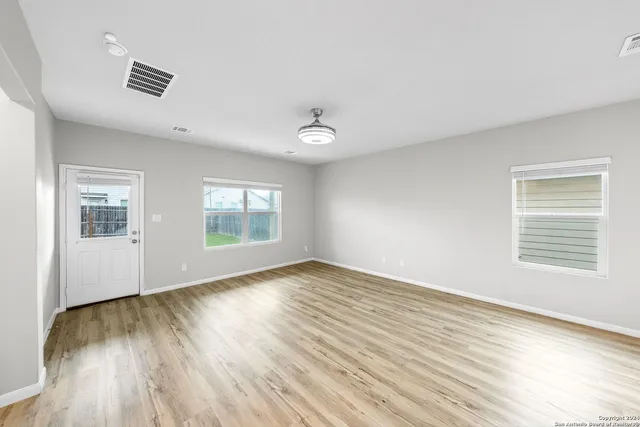 a view of empty room with wooden floor