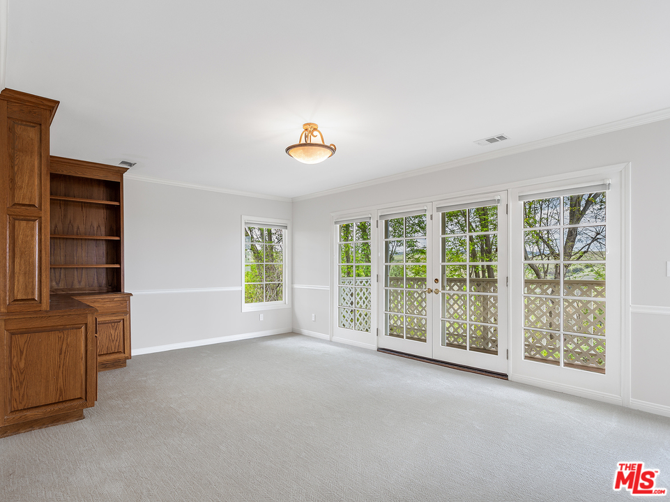 24835 Jacob Hamblin Road Hidden Hills, CA 91302 - Photo 13 of 29 an empty room with windows and cabinet