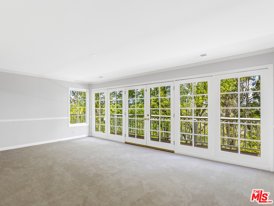 24835 Jacob Hamblin Road Hidden Hills, CA 91302 - Photo 15 of 29 an empty room with a large window and kitchen view