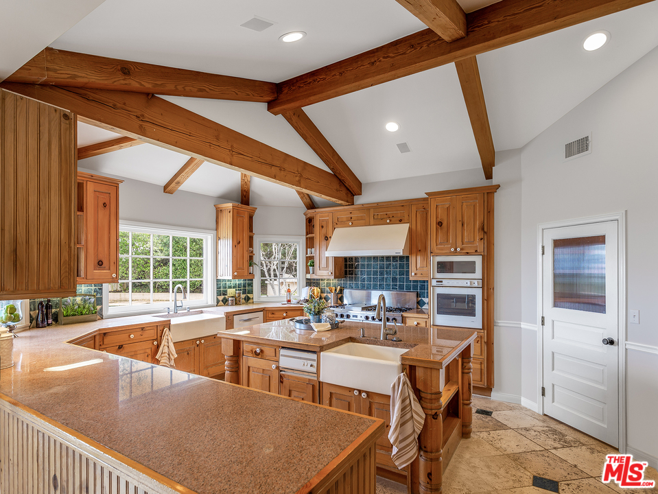 24835 Jacob Hamblin Road Hidden Hills, CA 91302 - Photo 3 of 29 a kitchen with kitchen island a large window in it
