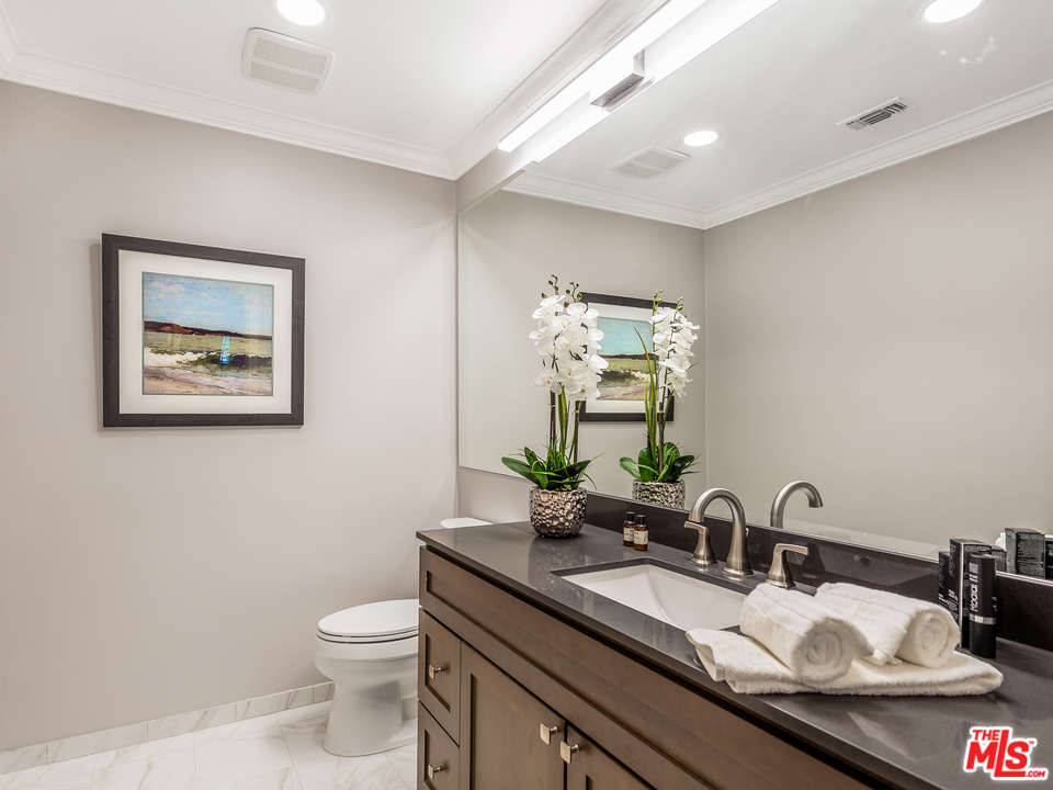 24835 Jacob Hamblin Road Hidden Hills, CA 91302 - Photo 10 of 29 a bathroom with a granite countertop toilet sink and mirror