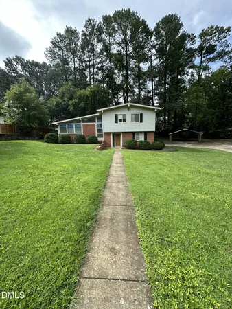 a house with green field in front of it