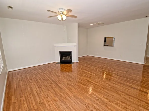 a view of empty room with wooden floor and fireplace