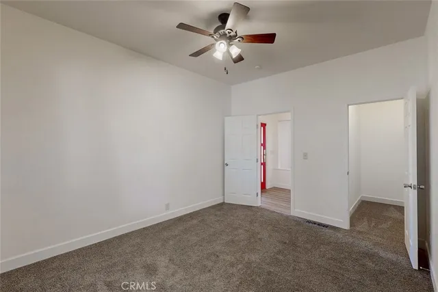 a view of a livingroom with a ceiling fan and kitchen space
