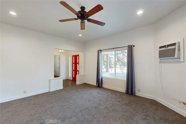an empty room with a window and a fan