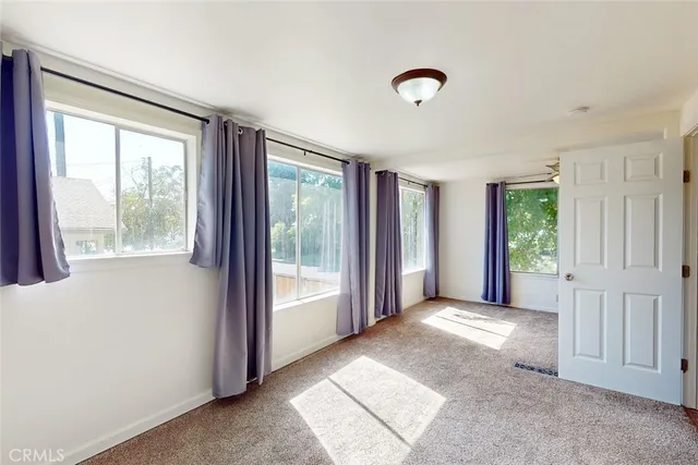 an empty room with chandelier fan