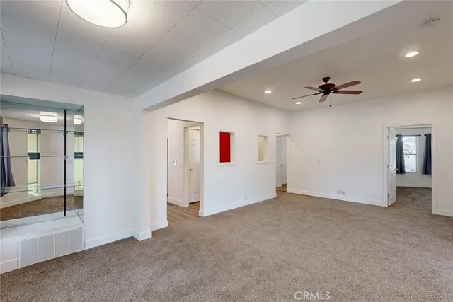 an empty room with closet and a ceiling fan