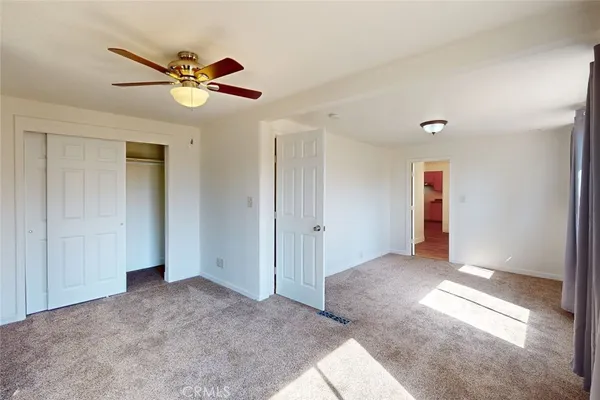 a view of a livingroom with wooden floor and a ceiling fan