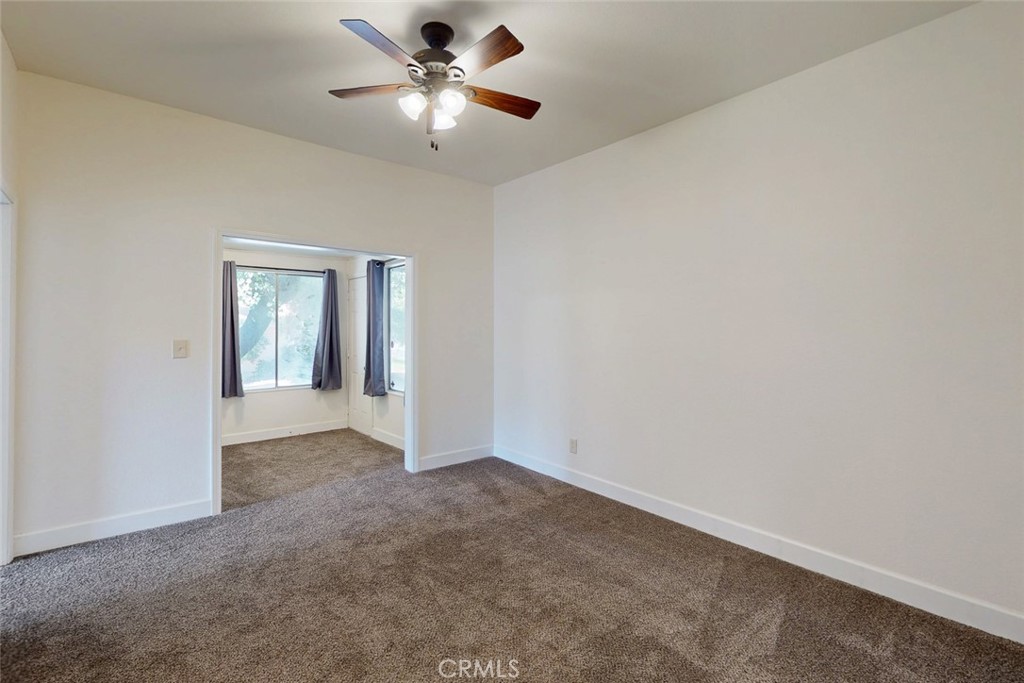 1585 Sycamore Street Gridley, CA 95948 - Photo 25 of 66 an empty room with a chandelier fan and windows