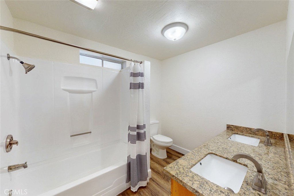 1585 Sycamore Street Gridley, CA 95948 - Photo 35 of 66 a bathroom with a granite countertop sink a toilet and bathtub