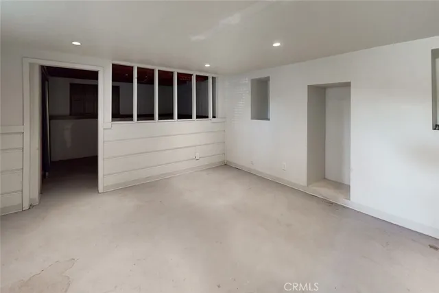 a front view of a house with a garden and trees